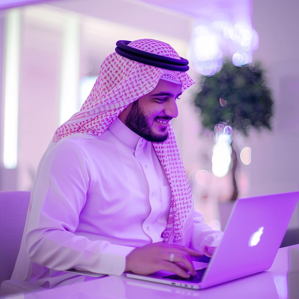 رجل سعودي ينظر إلى اللاب توب
