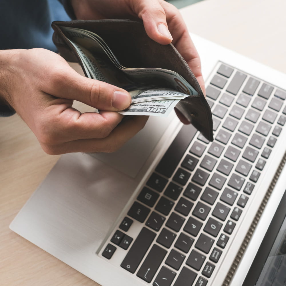 يد تحمل محفظة بها نقود