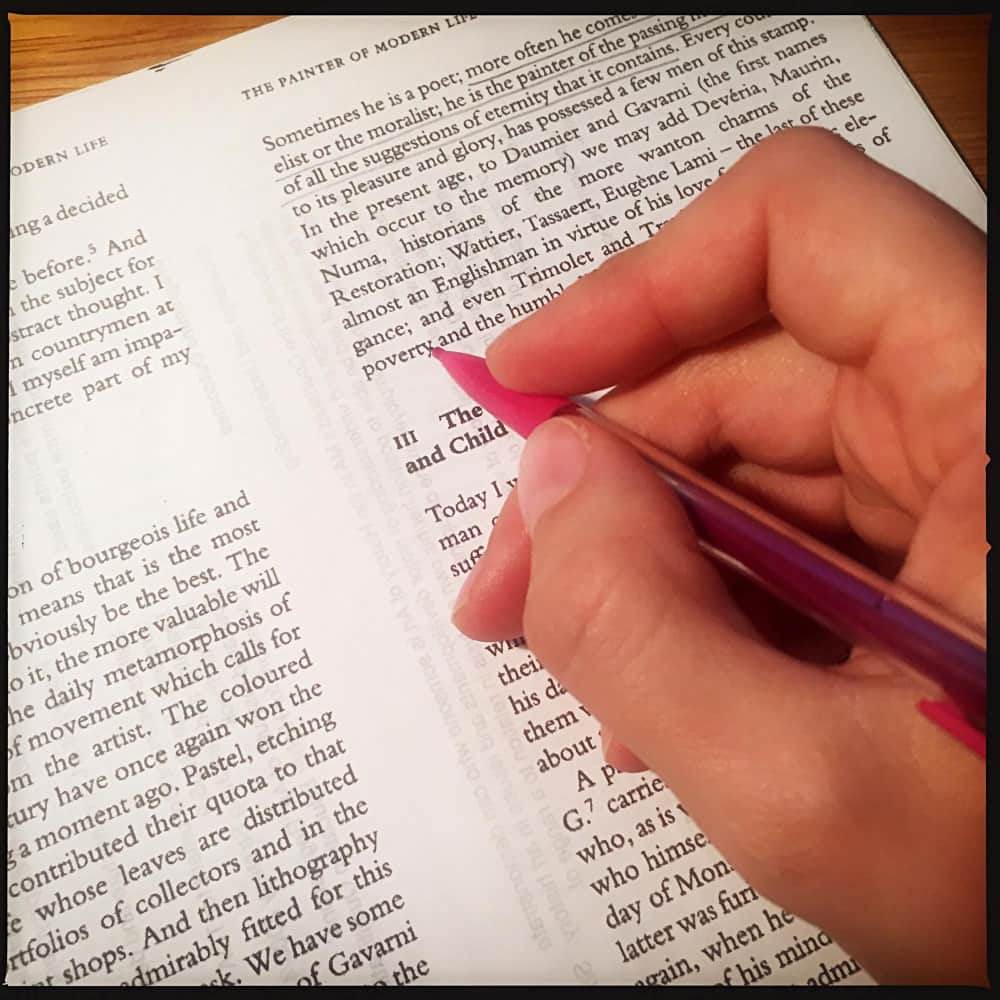 يد تمسك بقلم وتشير إلى كلمات إنجليزية