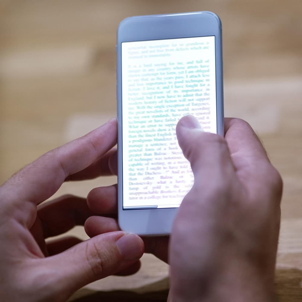 يد تحمل هاتف محمول يظهر نص باللغة الإتجليزية