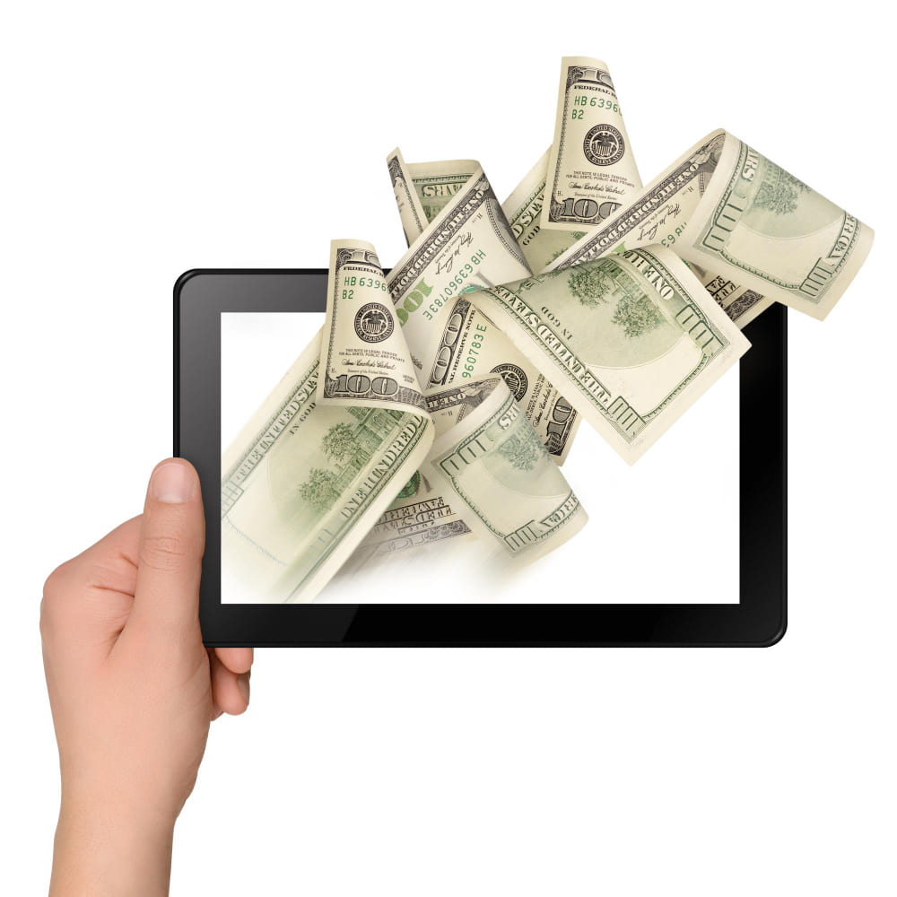 يد تمسك تابلت يخرج منه نقود