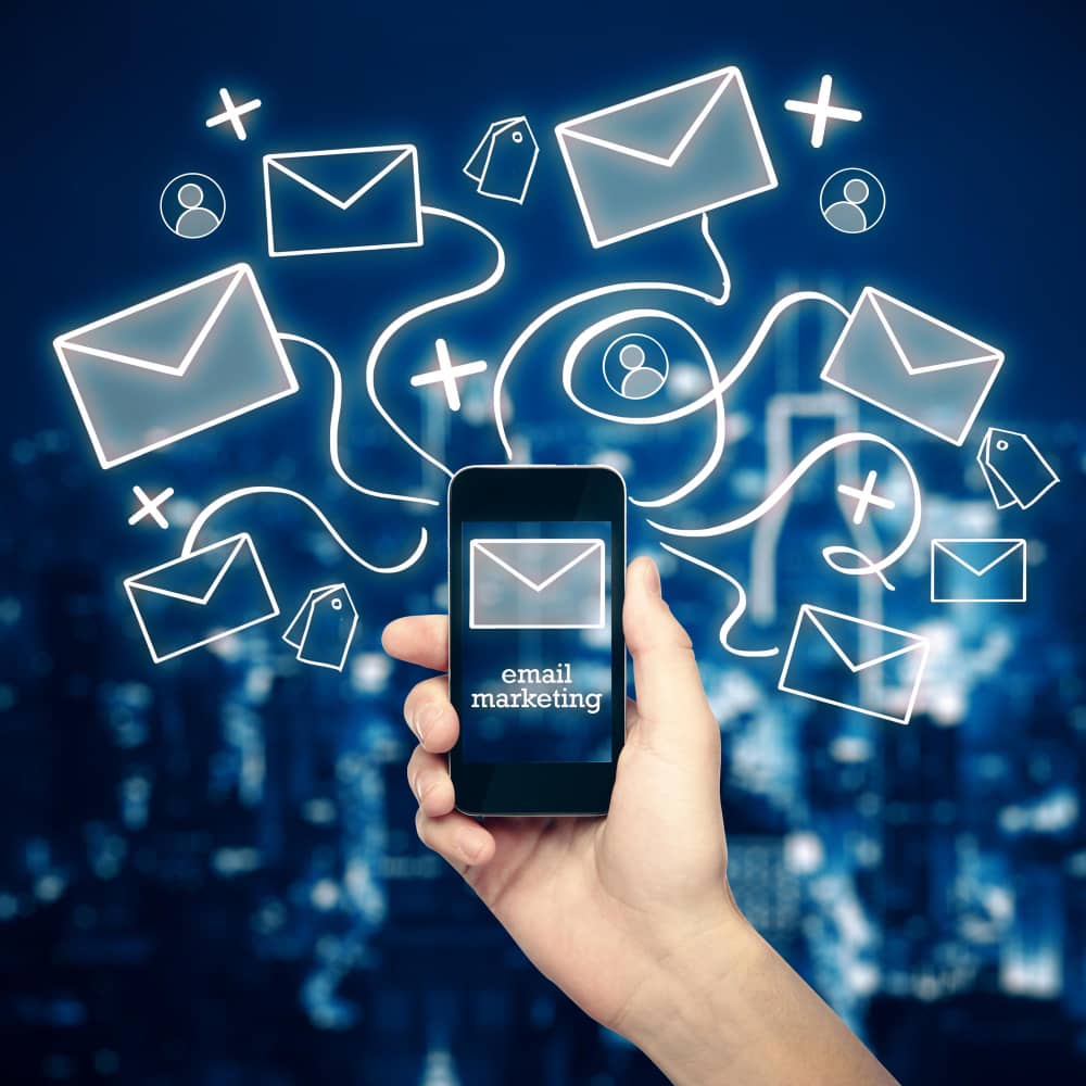 يد تمسك هاتف محمول يظهر التسويق بالبريد الالكتروني