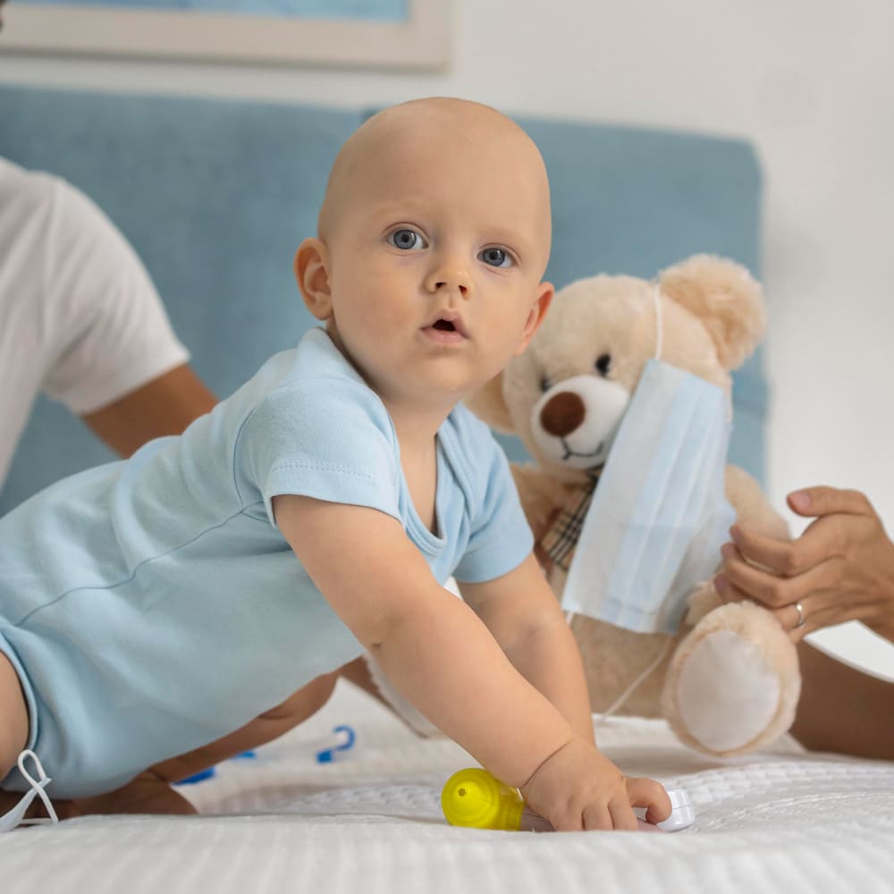 طفل على السرير وبجانبه لعبة