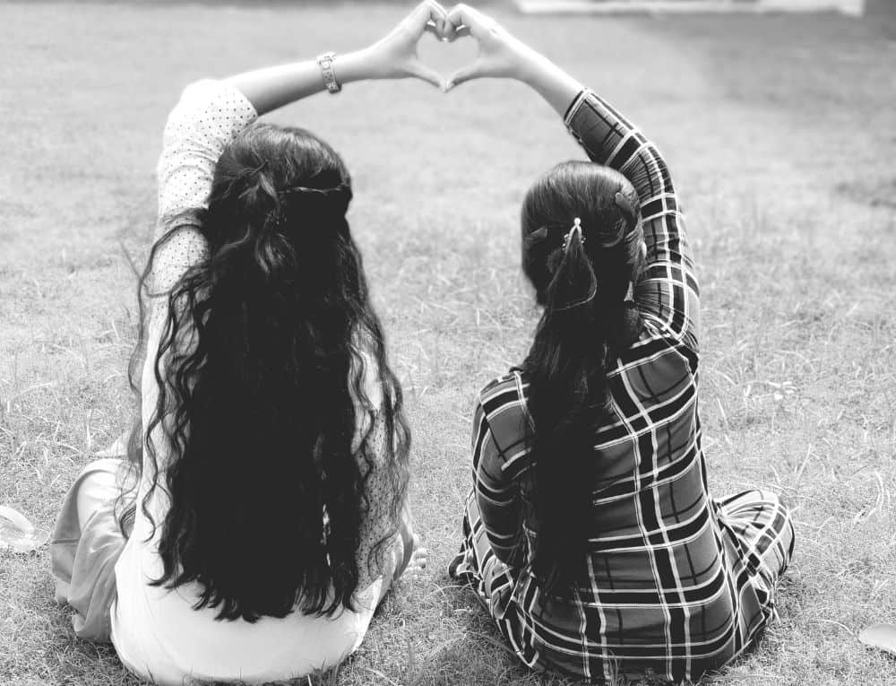 صديقتان يرسمان قلب باليد