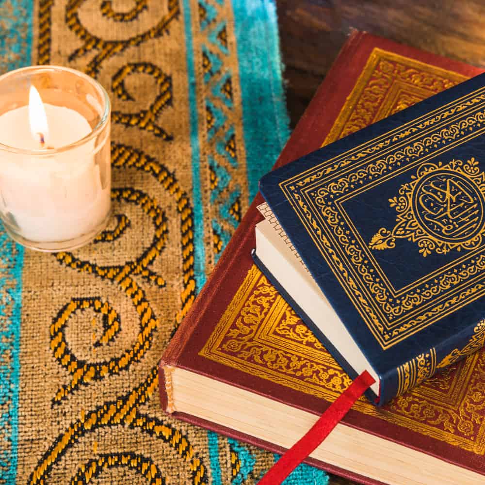 مجموعة مصاحف وبجانبهم شمعة مضيئة