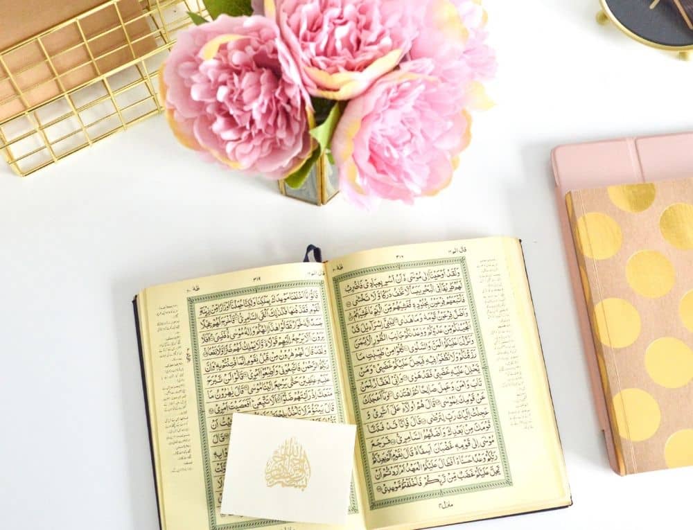 مصحف مفتوح وبجانبه مجموعة من الزهور