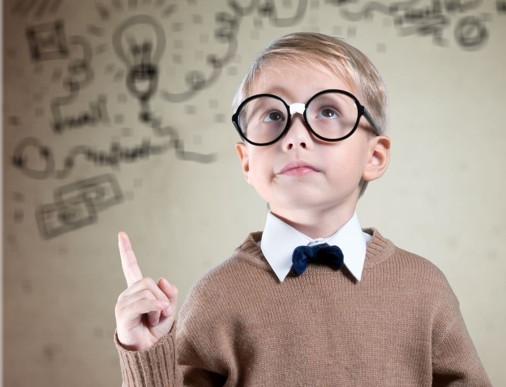 طفل يرتدي نظارة طبية ويشير بإصبعه إلى أعلى