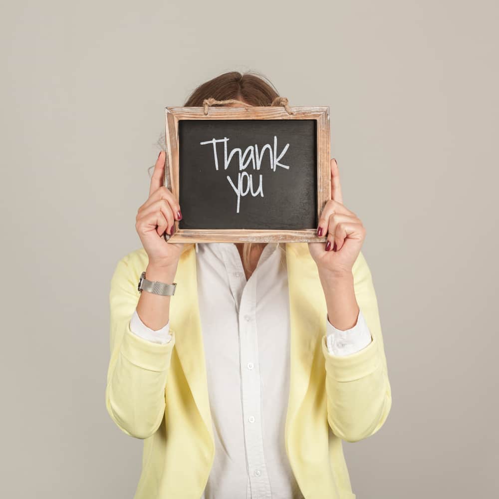 فتاة تحمل برواز صغير عليه عبارة شكر