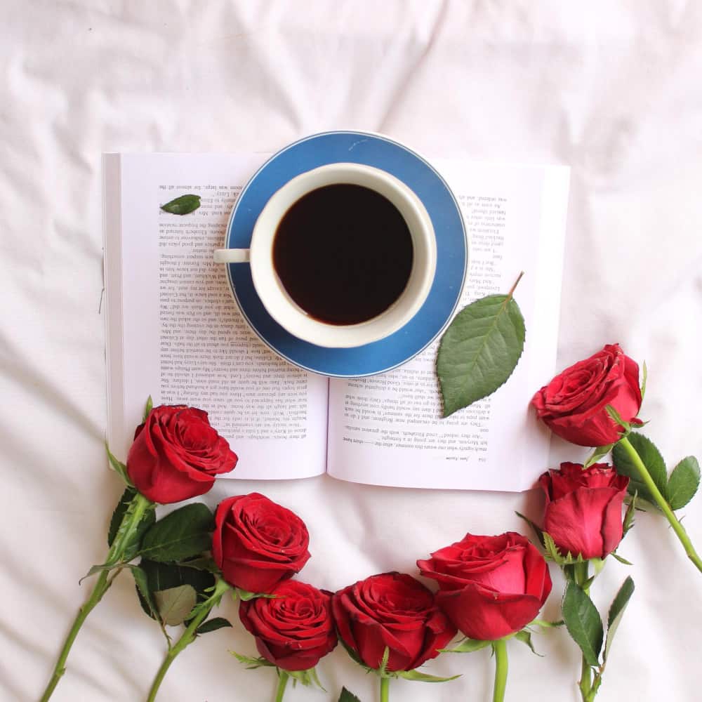 ورود حمراء حول كوب من القهوة