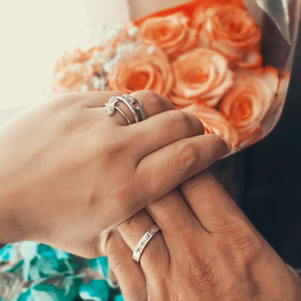 أيادي تلبس دبل بجوار بوكيه زهور