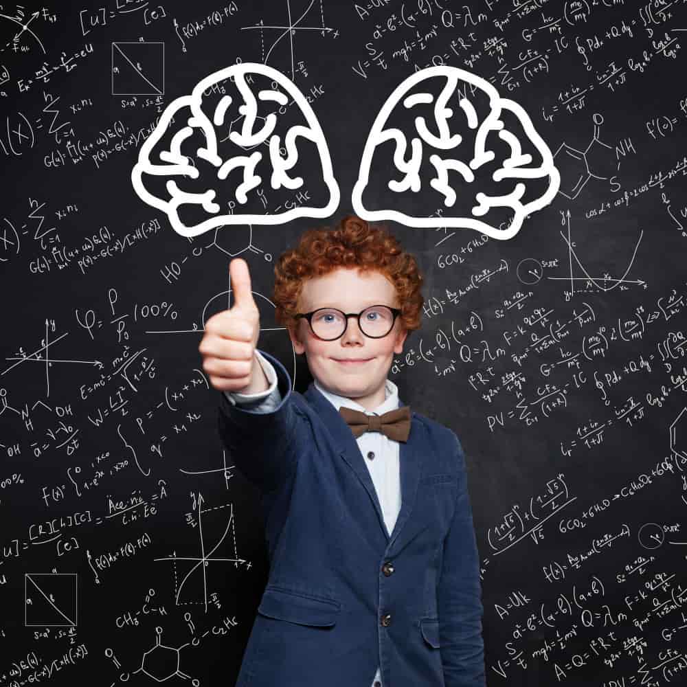 طفل يرتدي بدلة ونظارة يقف أمام سبورة