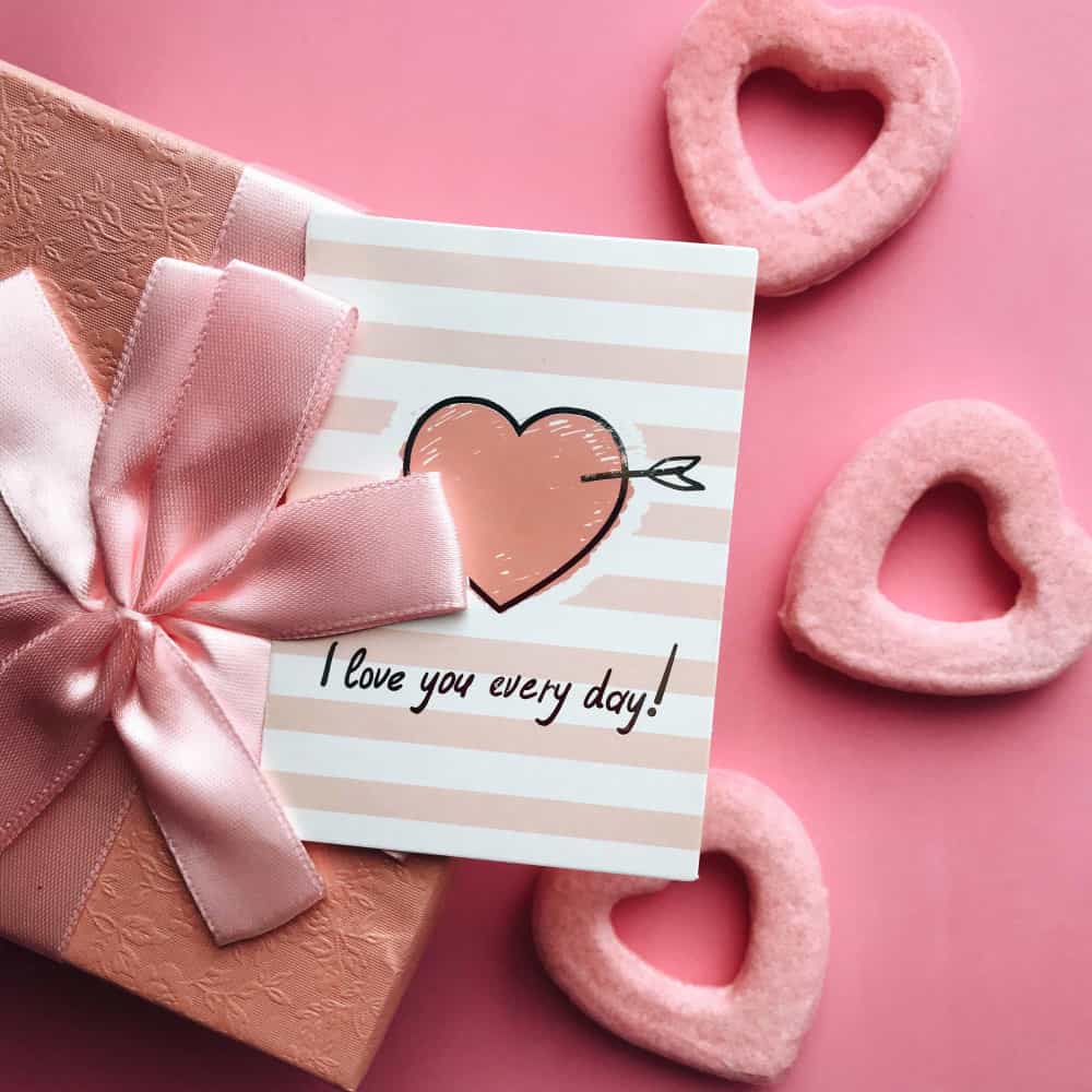 عبارة حب بجانب قلوب وردية اللون