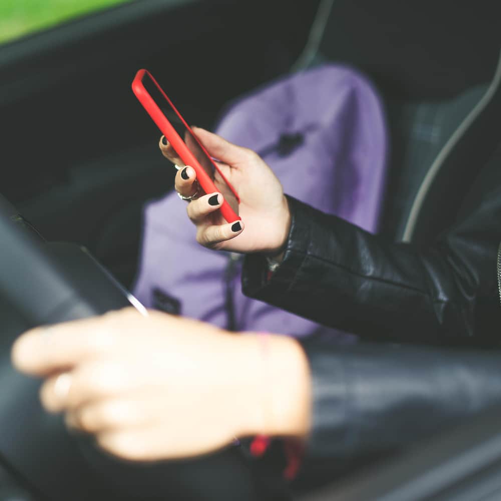 يد فتاة تمسك هاتف داخل سيارة